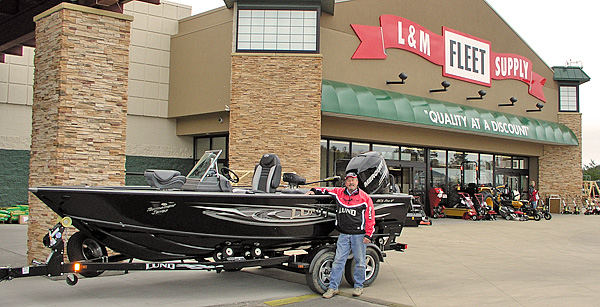 Tom Neustrom pauses for a photo with his Lund Boat outside the L&M Supply flagship store in Grand Rapids, MN during an In-Store Appearance.